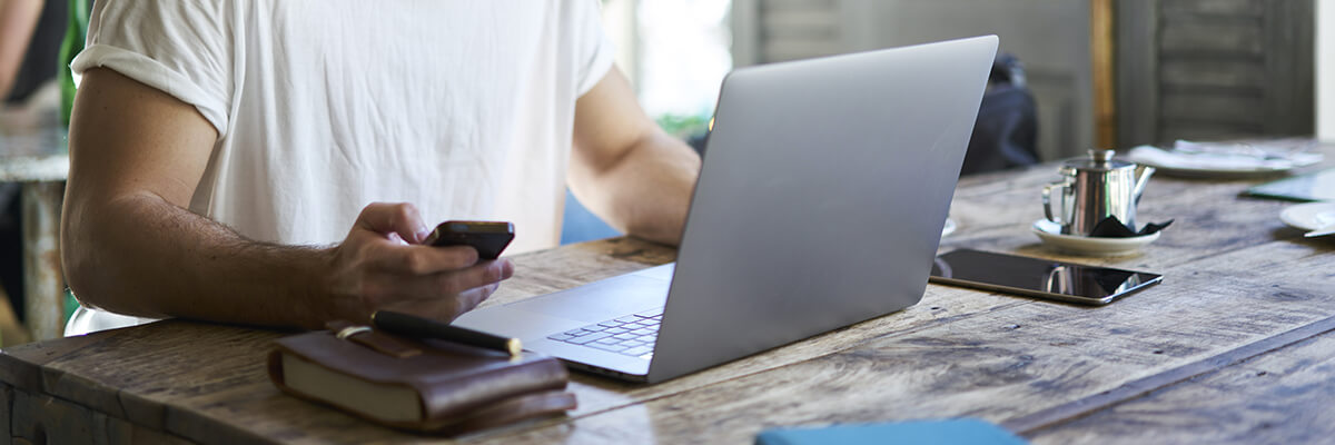 man on laptop and phone