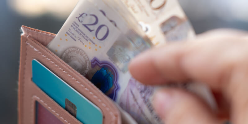 Hand removing bank notes from wallet