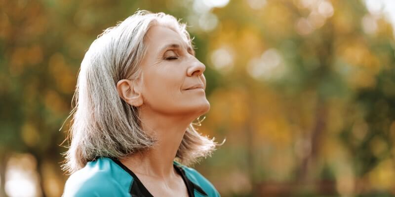 Woman closing her eyes and taking a deep breath